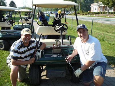 Golf
Greg and Schmoe and their hood ornament trophy
