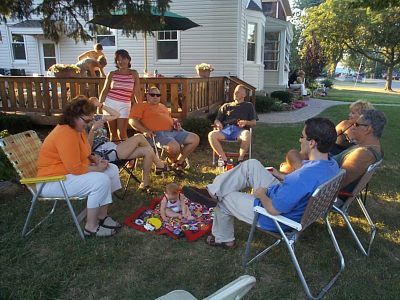 My brother Rick is in orange, near the center of the picture. Liz is standing behind him.  My niece Heather is sitting on the porch.